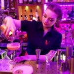 Young lady pouring cocktail embroidered blouse